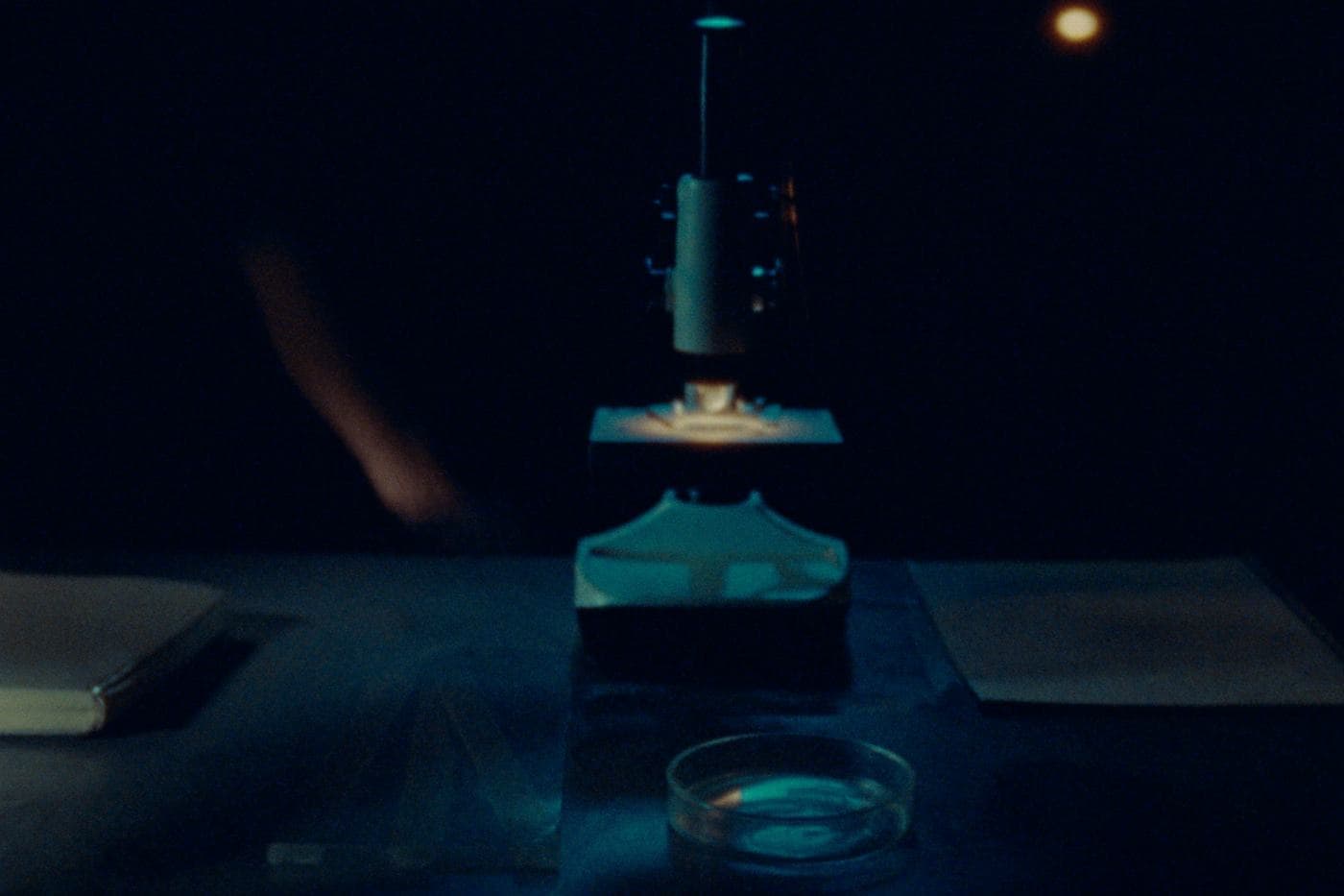 A light microscope on a lab bench at night
